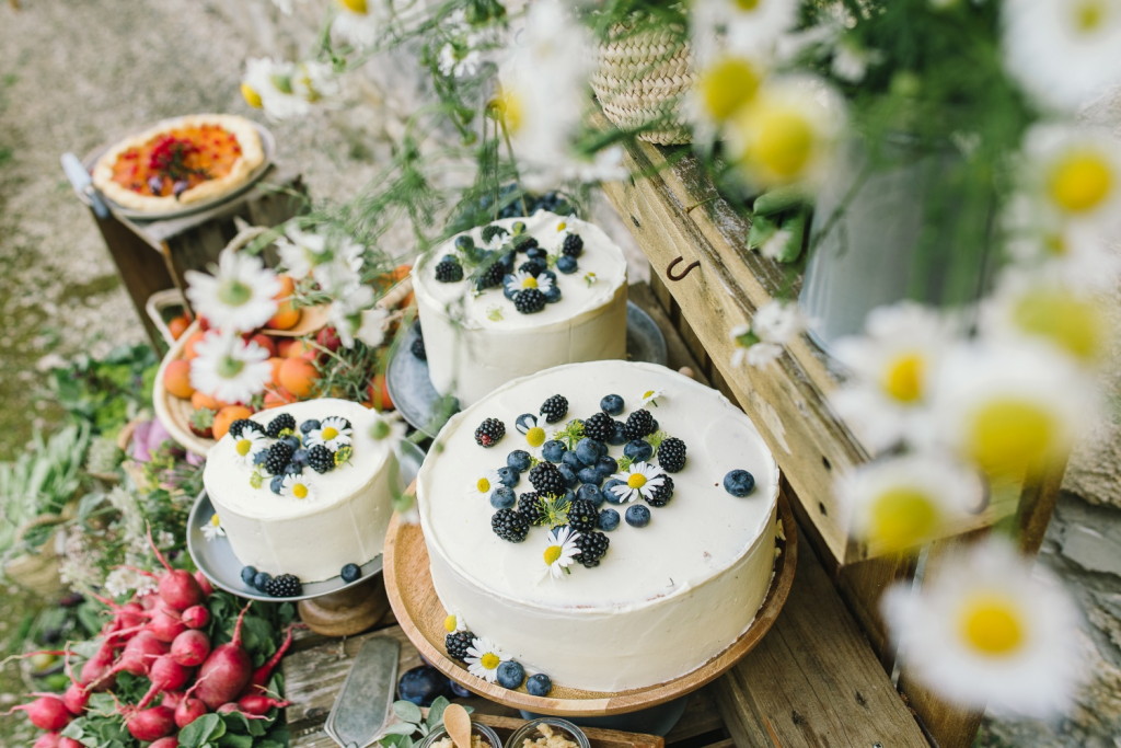 Drei verschieden gro&szlig;e vegane wei&szlig;e Hochzeitstorten mit Blaubeeren on Top